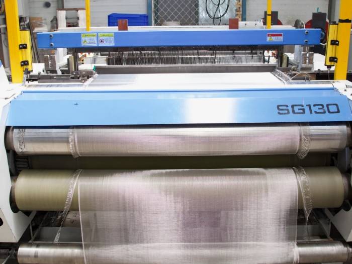 设备正在运行，进行丝网生产和裁边。