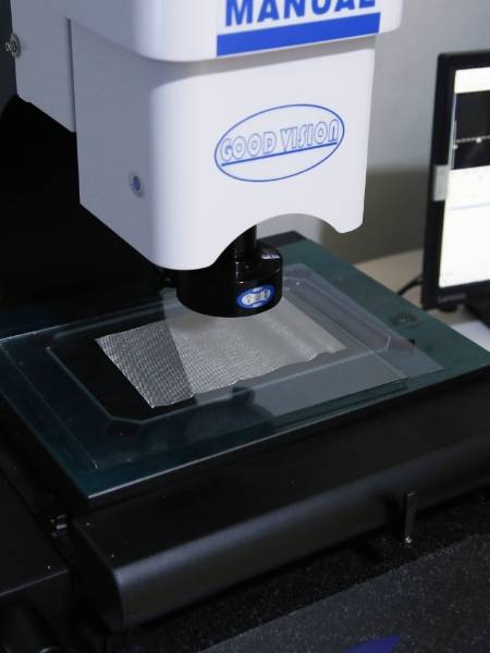 我们的质检员正在检查不锈钢编织网的网孔尺寸。